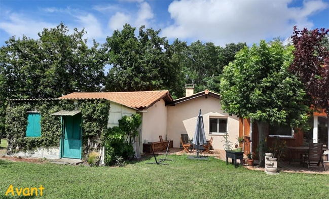 Maison avec terrasse en bois, jardin verdoyant et volets turquoise sous un ciel bleu. Texte Avant en bas à gauche.
